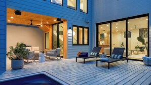 A modern outdoor deck with seating, a pool, and a view into the house. - Elizabeth House by Avantstay Saltwater Plunge Pool + Casita + Firepit (Austin)
