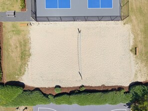 Ein Luftbild eines Gebäudes mit einer großen offenen Fläche, einem Zaun und einem Wasserspeicher im Vordergrund.