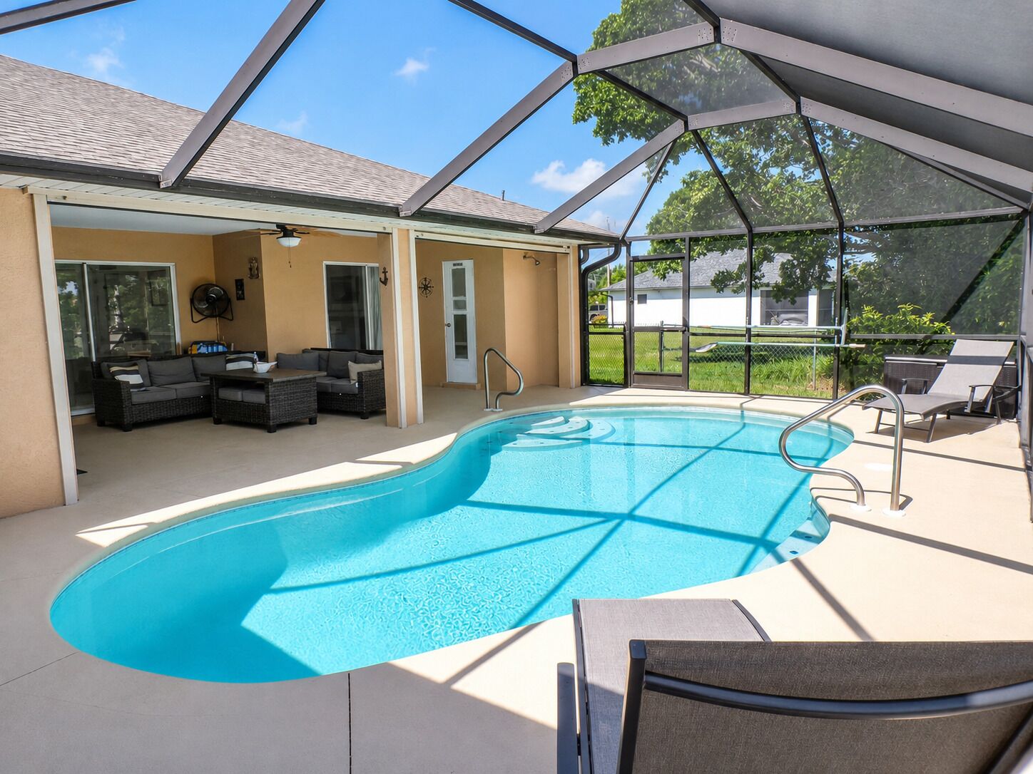 Una piscina techada con un área de patio, que incluye asientos y una puerta.