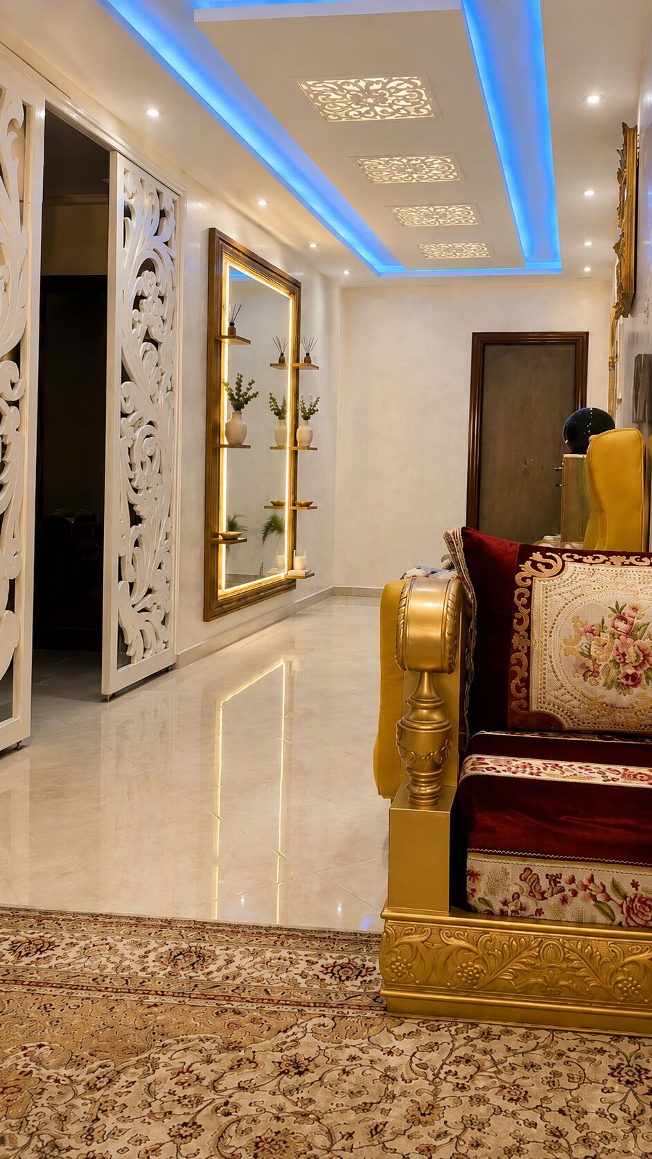 A luxurious room with a golden sofa, a large mirror, and a decorative ceiling.