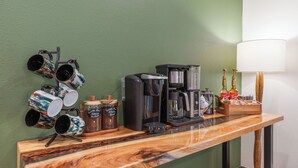 A bar area with a coffee machine, mugs, and a bottle of Torani syrup.