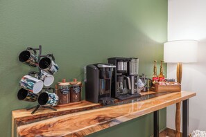 A bar area with a coffee machine, mugs, and a bottle of Torani syrup.