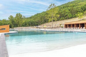 A swimming pool with lounge chairs and a wooden building.