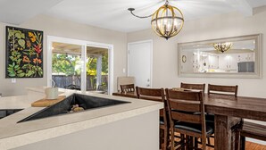 A modern kitchen with a dining area, a large window, and a ceiling light fixture. - Garden of the Gods Cottage-4B/3b Pioneer Park (Colorado Springs)