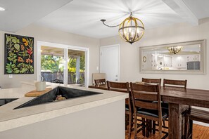 A modern kitchen with a dining area, a large window, and a ceiling light fixture. - Garden of the Gods Cottage-4B/3b Pioneer Park (Colorado Springs)