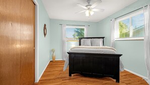 A bedroom with a bed, a ceiling fan, a window with blinds, and a wooden floor. - Garden of the Gods Cottage-4B/3b Pioneer Park (Colorado Springs)