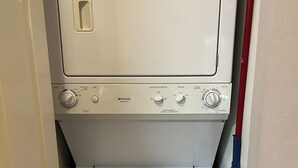 Eine kompakte, weiße Waschmaschine mit Frontlader und einer Bedienblende mit verschiedenen Programmen.
