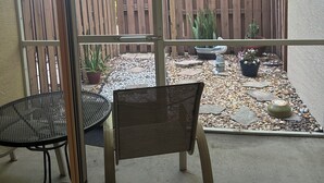 Eine Terrassenfläche mit Holzzaun, Pflanzkübeln und einer Sitzgruppe.