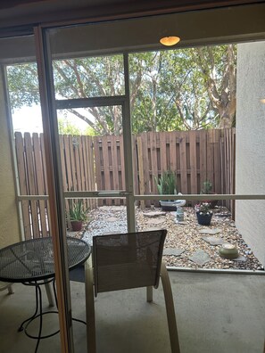 A patio area with a wooden fence, potted plants, and a seating arrangement. - Spacious 3-bedroom condo with pool/fitness center in lovely Fort Myers (Fort Myers)