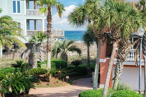 A beachfront property with a pathway leading to a building with a balcony overlooking the sea. - SeaHaven @ Laguna Key- 6BR "Almost Beachfront" Home, Pool, Tiki Bar, Game Garage (Gulf Shores)