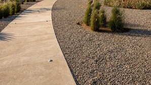 Un sendero sinuoso que conduce a un edificio, con un paisaje desértico al fondo.