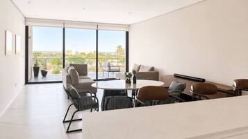 Un interior moderno con comedor, asientos y grandes ventanales que ofrecen vistas.