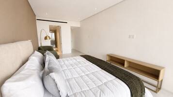 A modern bedroom with a large bed, a bedside table, and a built-in bench.