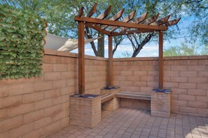 A brick-built outdoor seating area with a wooden pergola structure. - Spacious Central Tucson Home • Garage & Dogs OK (Tucson)