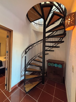 A spiral staircase with a wooden finish and metal railings, leading to an upper floor. - 2 bedroom condo with panoramic views of Romantic Zone, bay and mountains (Puerto Vallarta)