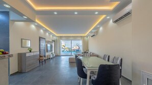 A modern kitchen with a dining area, a large window, and a view of the outdoors.