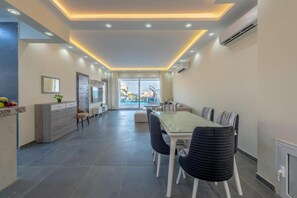 A modern kitchen with a dining area, a large window, and a view of the outdoors.