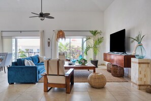 A modern living room with a sofa, chair, coffee table, and a TV. - Luxury two-story penthouse condo at the beach in the heart of Punta de Mita! (Punta de Mita)