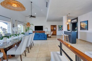 A spacious living area with a dining table, sofas, and a TV. - Luxury two-story penthouse condo at the beach in the heart of Punta de Mita! (Punta de Mita)