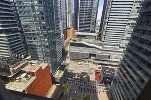 A high-rise urban area with modern buildings, a parking lot, and a small green space. - Chic Upscale 2BR Toronto Condo with Gym (Toronto)
