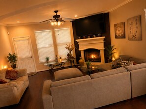 A living room with a fireplace, sofa, and a television.