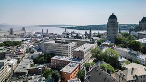 A cityscape with a prominent building with a tower, surrounded by other buildings and a river. - 114 Cook - Loft in the Heart of Old Quebec (Québec)