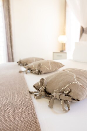 A bed with a beige bedspread and pillows with tassels. - BEAUVALETTE SOLEIL (Sainte-Anne)