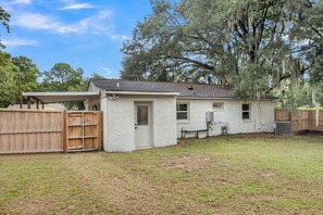 A single-story house with a fenced backyard, a covered patio, and a wooden fence. - The Lightkeeper's Cottage Beaufort, SC (Beaufort)