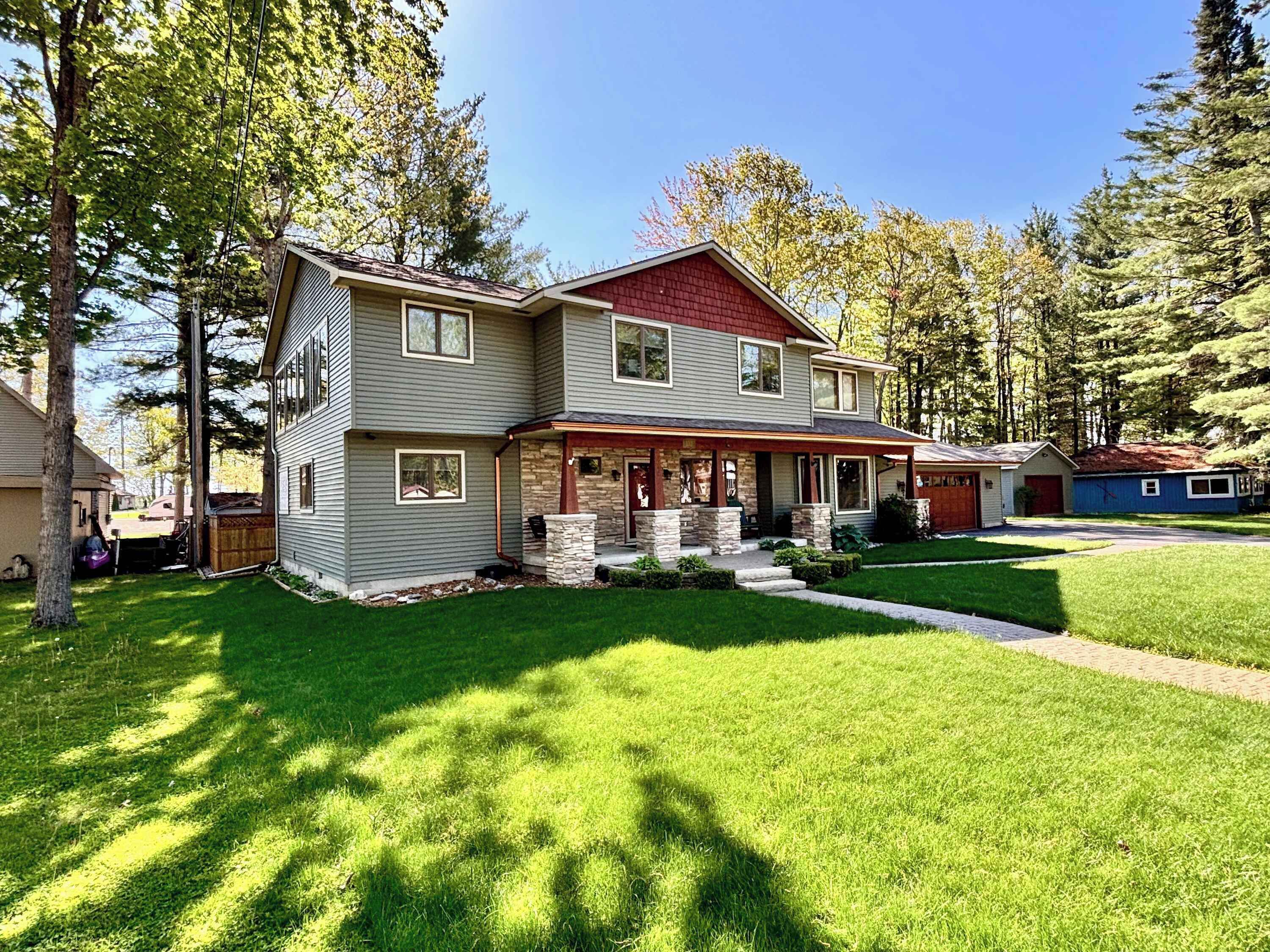 A two-story house with a front porch, a garage, and a well-maintained lawn.