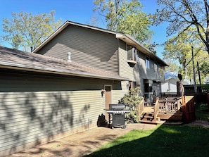 A residential house with a garage, a patio area, and a wooden deck.