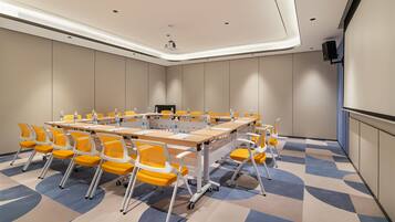 A conference room with a large table, yellow chairs, water bottles, and a projector.