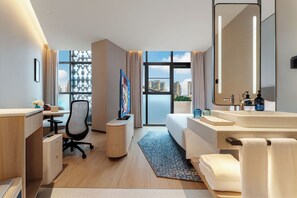 Ein modernes Hotelzimmer mit Schreibtisch, Stuhl, Bett und Badezimmer.