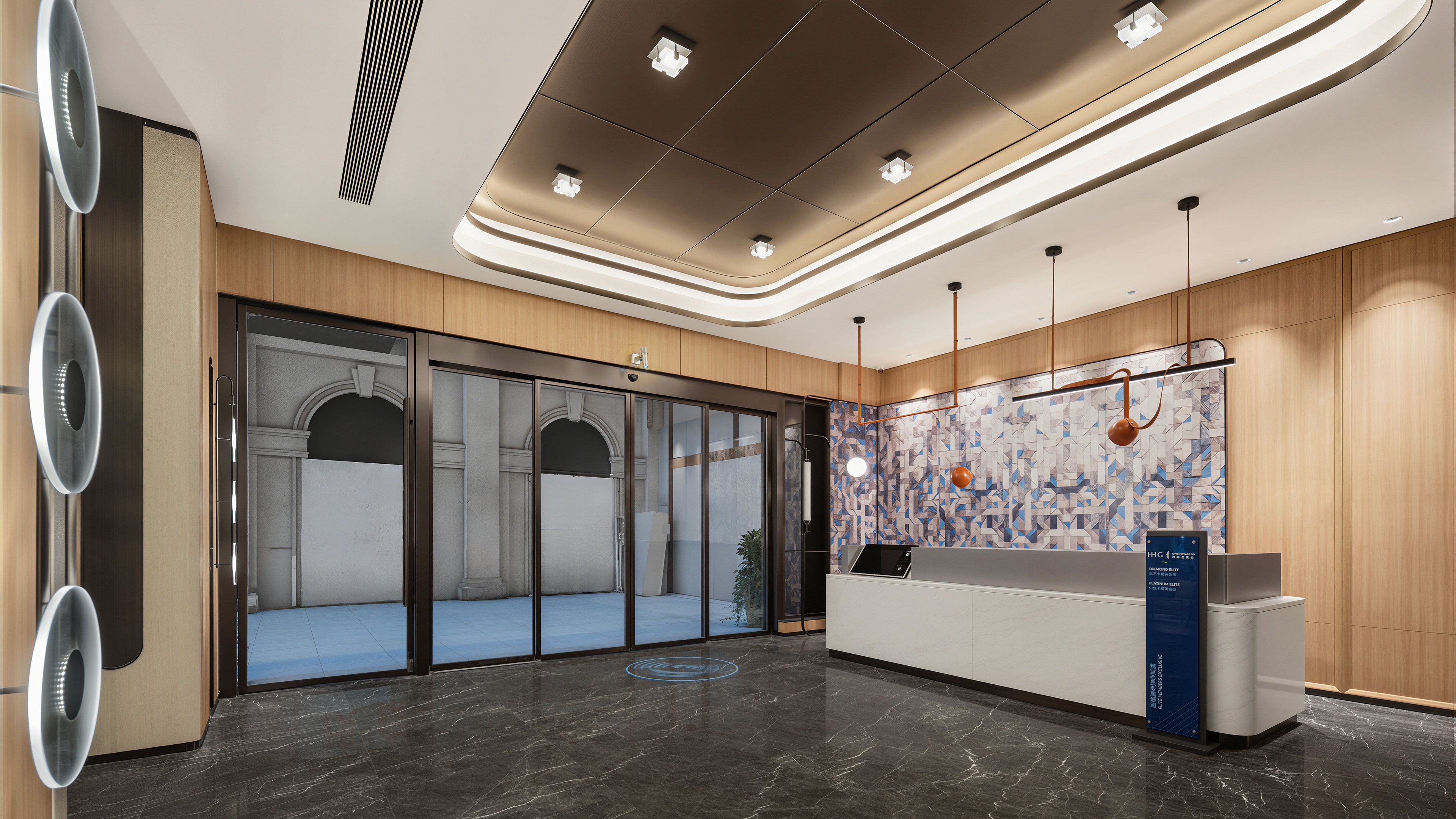 A modern reception area with a glass door entrance, a reception desk, and a patterned wall.