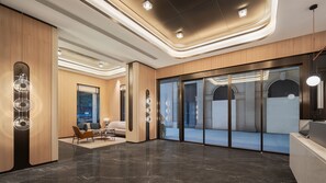 Eine moderne Hotelhalle mit Marmorboden, Holzvertäfelung und einer Rezeption.
