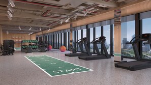 Ein Fitnessstudio mit Laufbändern, Kraftgeräten und einer grünen Tartanbahn.