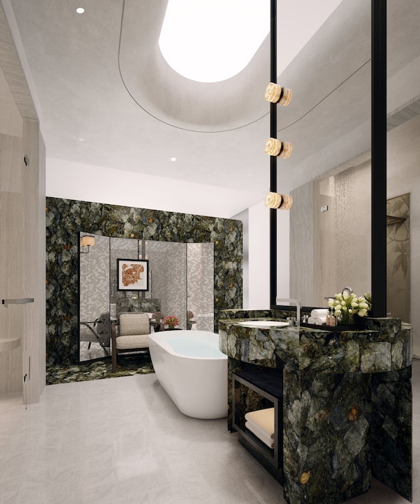 Ein modernes Badezimmer mit freistehender Badewanne, Waschtisch aus Marmor und einem großen Spiegel.