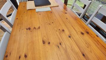 Una mesa de madera con sillas, un cuaderno y una carpeta negra.