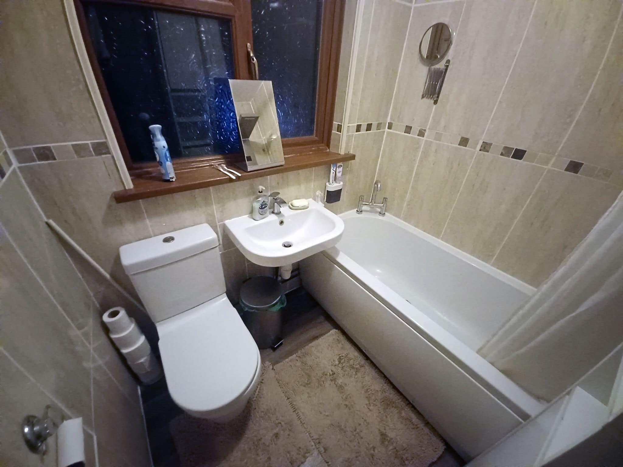 A small bathroom with a toilet, sink, and bathtub.