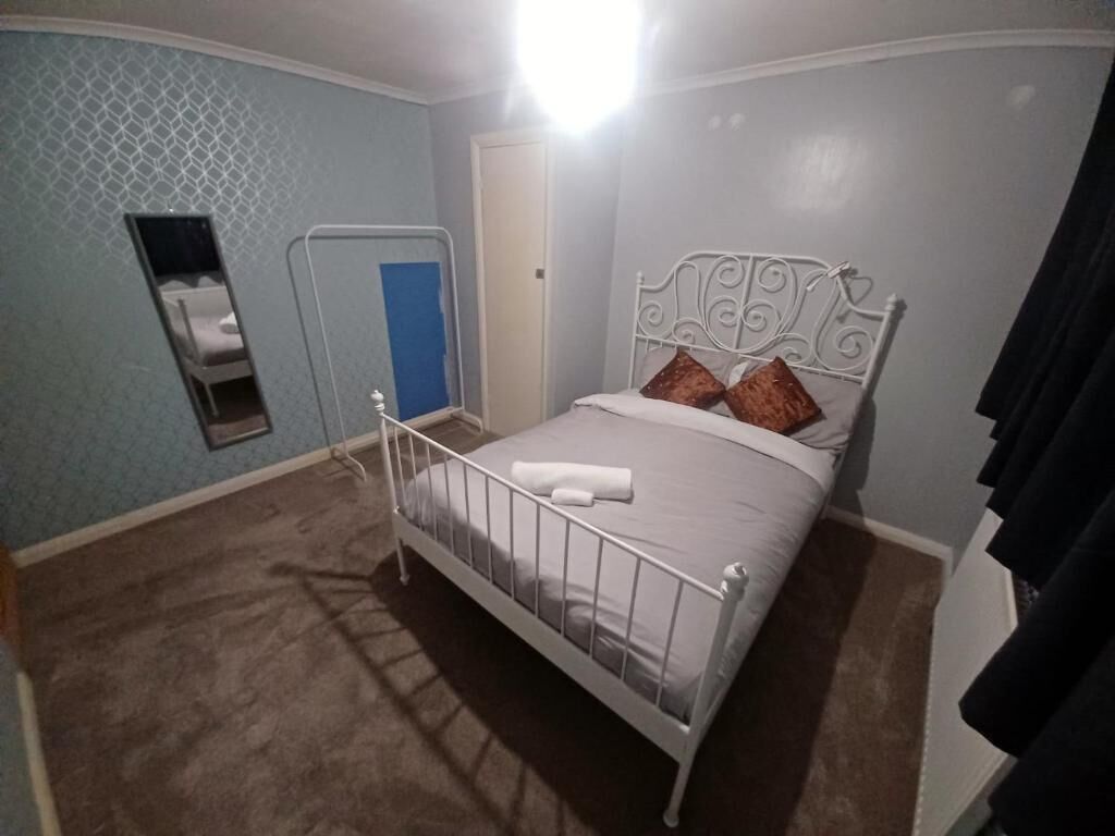 A bedroom with a single bed, a door, and a small window.