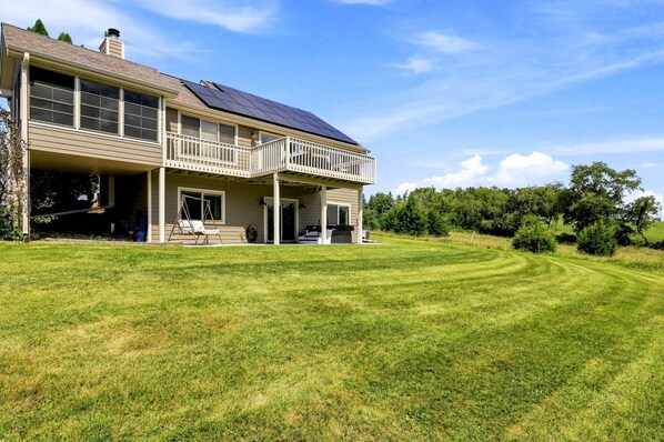 A two-story house with a covered porch and a large lawn.