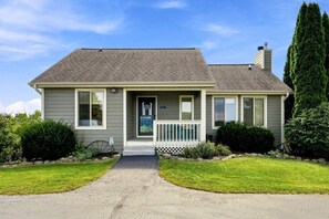 A single-story house with a front porch, a mailbox, and a chimney.