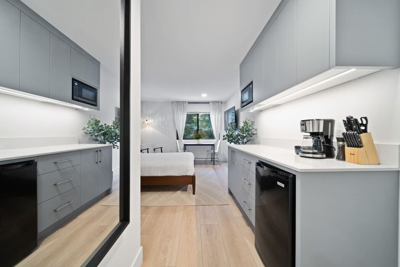 A compact kitchen with built-in appliances, a dining area with a view, and a separate sleeping area.