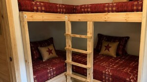 A bunk bed with a wooden ladder, two pillows with star designs, and a patterned bedspread. - New Cottage, Premium Comfort, Blue Ridge Mtns, Ski, Golf (Newland)