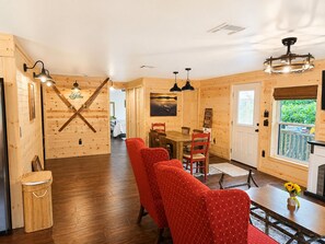 A wooden interior with a dining area, red upholstered chairs, and a wooden floor. - New Cottage, Premium Comfort, Blue Ridge Mtns, Ski, Golf (Newland)