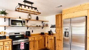 A modern kitchen with wooden cabinets, stainless steel appliances, and a built-in microwave. - New Cottage, Premium Comfort, Blue Ridge Mtns, Ski, Golf (Newland)