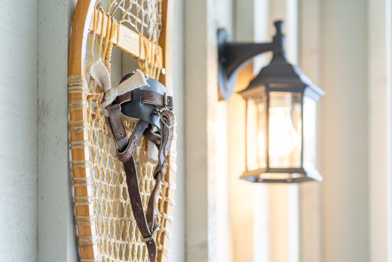 A door with a metal gate and a wall-mounted lantern.