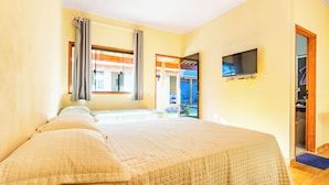 Una habitación de hotel con cama, televisión y vistas al exterior.