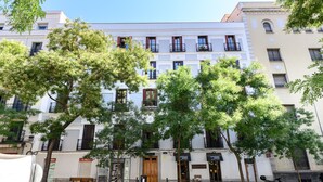 A multi-story building with balconies, trees in front, and a street in front. - (FER3452) 1 bedroom penthouse in Moncloa (Madrid)