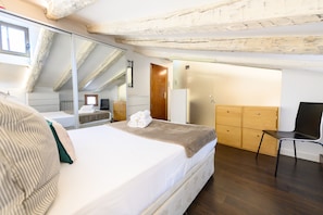 Ein Schlafzimmer mit Bett, Stuhl, Kleiderschrank und Spiegel.