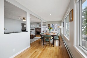 A modern interior with a dining area, kitchen, and living space. - The Nahant Perch: ocean view, walk to beach (Nahant)